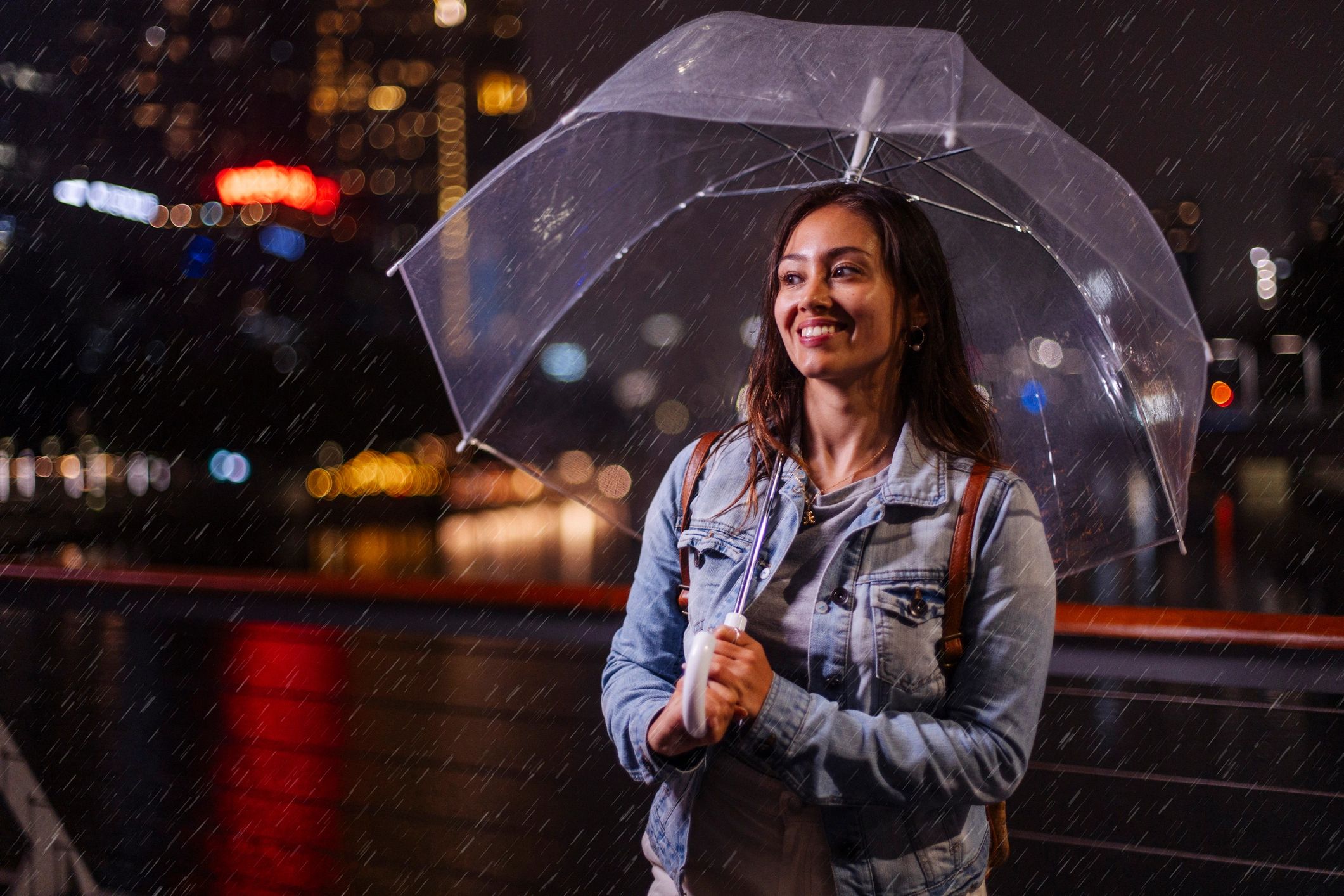Person with umbrella in rain at night with neon lights